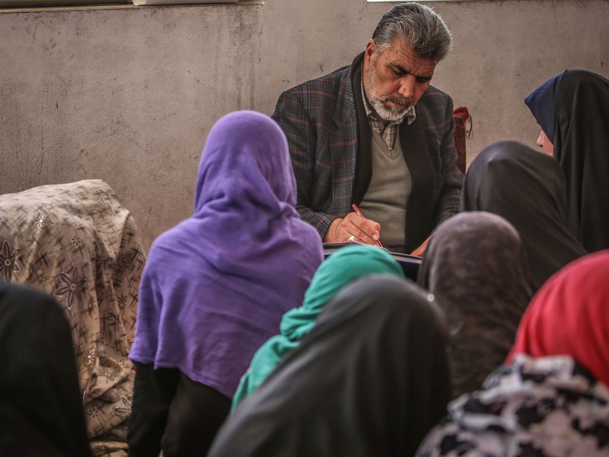 An Afghan instructor guiding learners during a group lesson